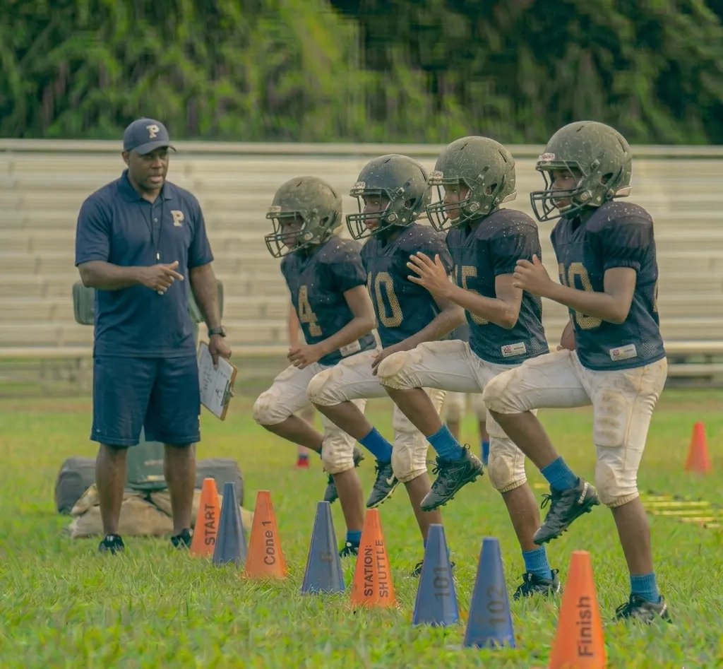 youth football players doing high knees warm up drill