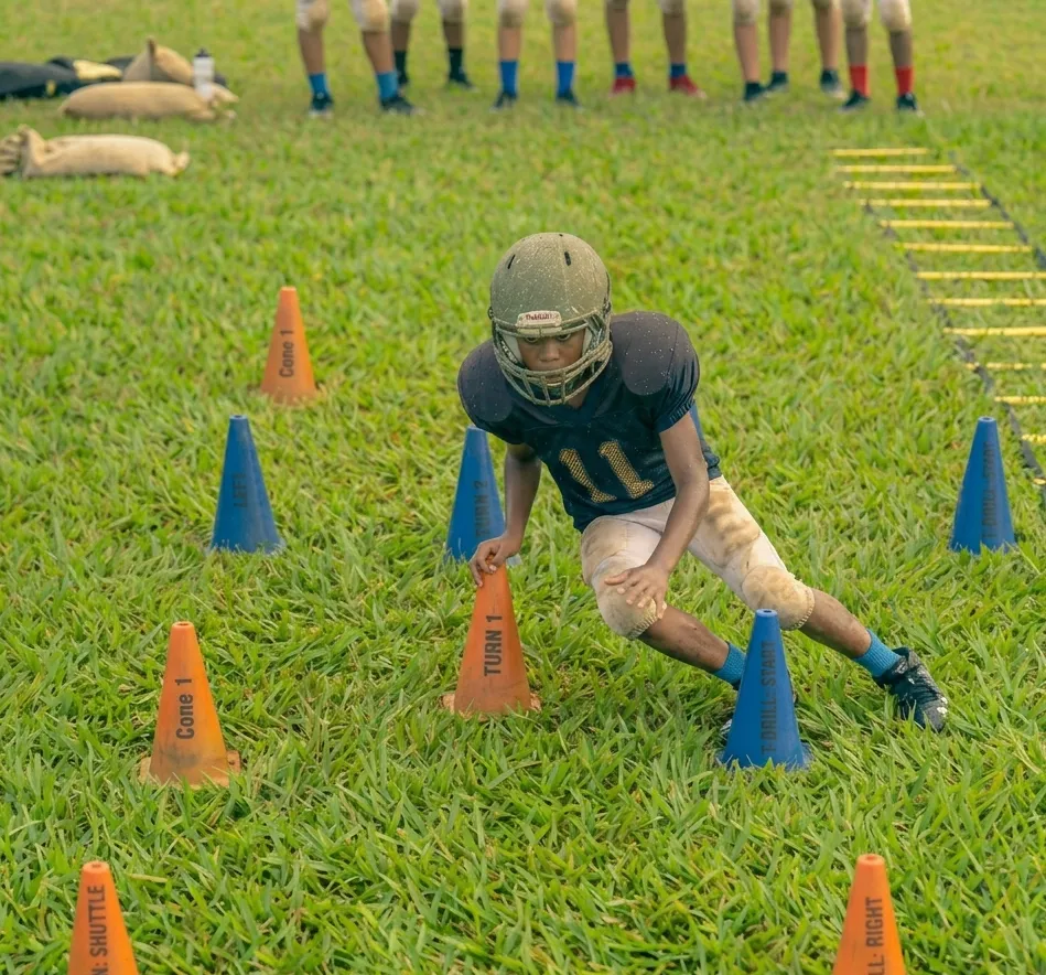 football player weaving through zig zag cone drill with sharp directional cuts